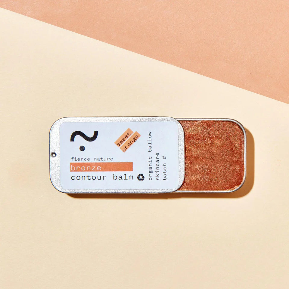 Bronze contour balm in a small container on a beige background