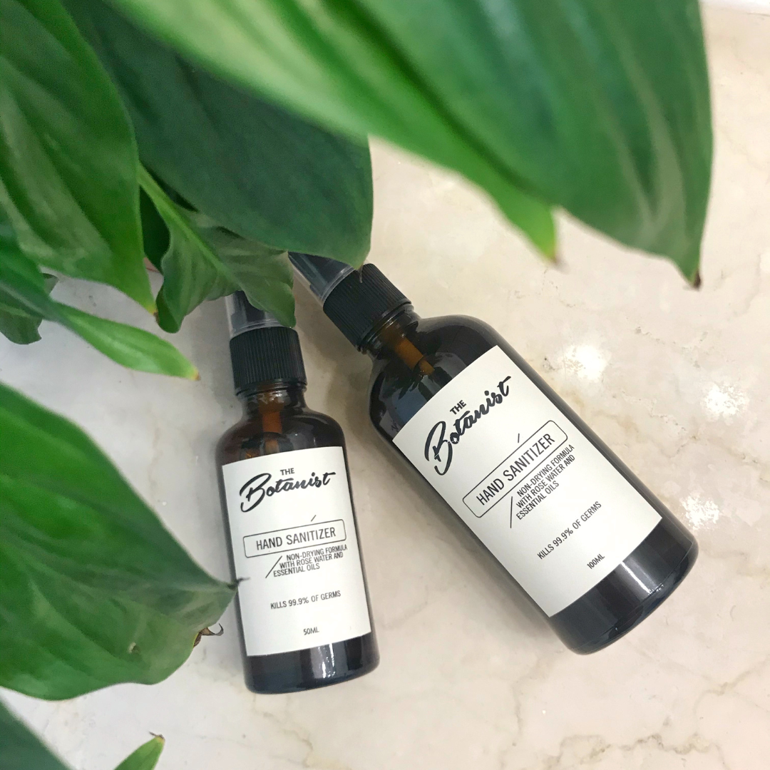 Two bottles of hand sanitizer with leaves on the background